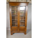 An oak bookcase with leaded glass doors and cupboard to the lower section, 42" x 15", 73" high