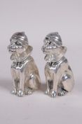 A pair of silver plated condiments in the form of dogs wearing cricket caps, 2½" long