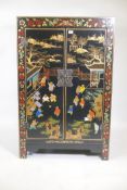 A Chinese black lacquer cabinet, the doors with painted and gilt decoration of children playing in a