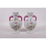 A pair of famille rose porcelain heart shaped vases with two handles and blossom decoration,
