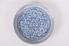 A Chinese blue and white porcelain dish decorated with a scrolling floral pattern, 7" diameter