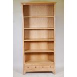 A blonde oak open shelf bookcase, with four shelves and draw to base, supplied by John Lewis, 73"