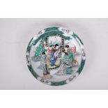 A famille vert porcelain charger decorated with a musician and audience, Kangxi six character mark