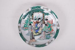 A famille vert porcelain charger decorated with a musician and audience, Kangxi six character mark