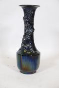 An Oriental famille noir ceramic vase with lustre glaze and raised decoration of a dragon, 21" high