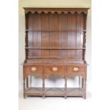 A C19th oak dresser, the delft rack with dummy drawers on a base of three drawers over an open pot