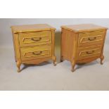 A pair of oak bedside chests with shaped tops and two drawers, raised on cabriole supports, 23" x