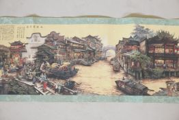 A Chinese printed scroll depicting a town scene, with character inscription panels to either end,