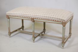 A painted and parcel gilt window seat, raised on six fluted supports, 44" x 20" x 21"