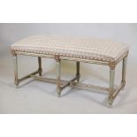 A painted and parcel gilt window seat, raised on six fluted supports, 44" x 20" x 21"