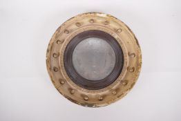 A C19th giltwood convex wall mirror of small proportions, with original oxidised glass, 13" diameter