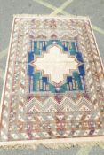 An Oriental style carpet decorated with geometric designs within multiple borders, 78" x 55"