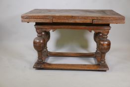 An antique Dutch oak drawleaf table, the plank top with two pull out leaves, raised on a shaped