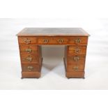A Victorian walnut pedestal desk with an inset faux leather top and nine drawers, 40" x 23", 27"