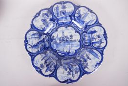 A petal shaped Delft pedestal tazza painted with waterside scenes, 12" diameter