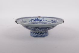 A blue and white shallow footed bowl with three metal mounts to rim and decorated with figures