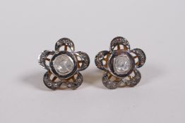 A pair of silver gilt and uncut diamond ears studs in the form of flowers