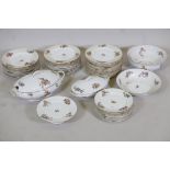 A Limoges floral decorated part dinner service comprising 10" and 12" oval tureens and covers, two