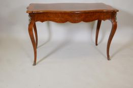 A French amboyne shaped top two drawer writing table, with inlaid decoration and inset figured walnt