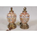 A pair of Oriental porcelain table lamps with raised gilt and enamel decoration and brass mounts,