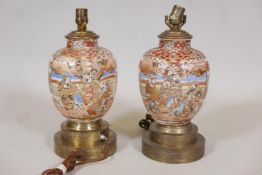 A pair of Oriental porcelain table lamps with raised gilt and enamel decoration and brass mounts,