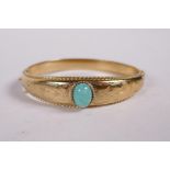 A 9ct rolled gold bangle set with a green hardstone, 2" x 2"