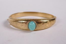 A 9ct rolled gold bangle set with a green hardstone, 2" x 2"