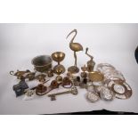 A collection of metal wares to include four Indian brass oil lamps, spice press, mixed metal plaques