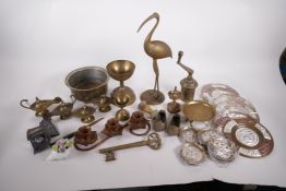 A collection of metal wares to include four Indian brass oil lamps, spice press, mixed metal plaques