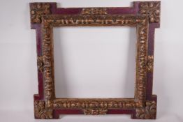 A carved giltwood and polychrome decorated picture frame with extended corners, 13" x 12" rebate