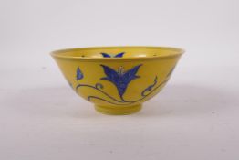 A yellow ground porcelain rice bowl with blue scrolling floral decoration, six character mark to