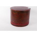 A red lacquer container with penwork decoration highlighted in gilt, the interior fitted with two