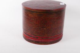 A red lacquer container with penwork decoration highlighted in gilt, the interior fitted with two