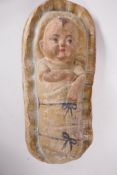 A painted papier mache figure of a baby in a basket, 'Moses', 19" long