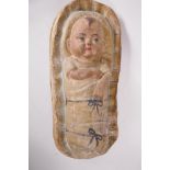 A painted papier mache figure of a baby in a basket, 'Moses', 19" long