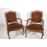 A pair of Continental walnut open armchairs on scroll feet with carved details, 38" high