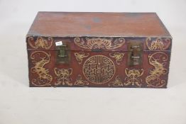 A chinoiserie lacquered pigskin trunk, with parcel gilt raised moulded decoration and brass