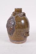 A Chinese Song style olive glazed pottery wine pourer with raised fruiting vine decoration, 5" high