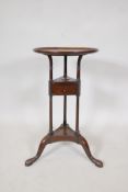 A Georgian mahogany wig stand with single drawer, raised on three columns and pad feet, the dished