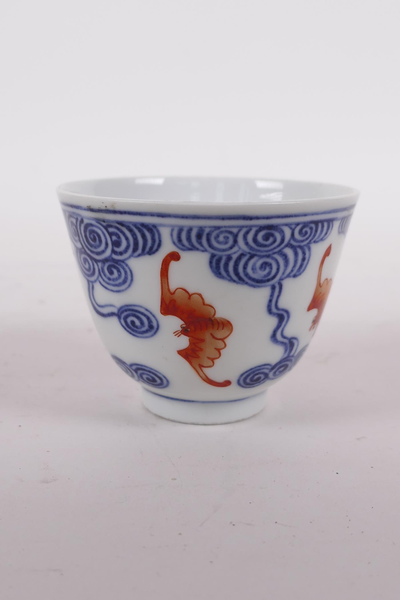 A Chinese blue and white porcelain tea bowl with iron red bat decoration, Quing six character mark