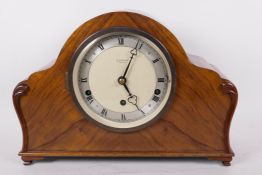 A walnut cased Westiminster chiming mantle clock with silvered chapter ring and Roman numerals, by