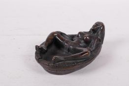 An bronzed metal ashtray of erotic form, 5" long