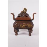 A Chinese bronze two handled censer and cover, decorated with mythical creatures and raised on