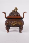 A Chinese bronze two handled censer and cover, decorated with mythical creatures and raised on