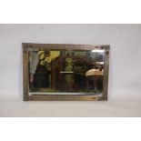 An Arts and Crafts brass framed wall mirror with bevelled glass plate, in the manner of Liberty, 37"