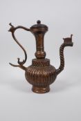 An Islamic gilt bronze ewer with a ribbed body and spiral shaped spout, 9" high