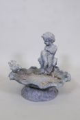 A lead bird bath in the form of a cherub seated upon a clam shell, 14" x 14"