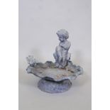 A lead bird bath in the form of a cherub seated upon a clam shell, 14" x 14"