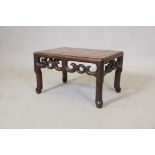 A Chinese rosewood low table/stande with scrolling pierced frieze, raised on shaped supports,