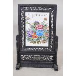 A Chinese porcelain table screen with floral decoration, mounted in a carved and pierced hardwood